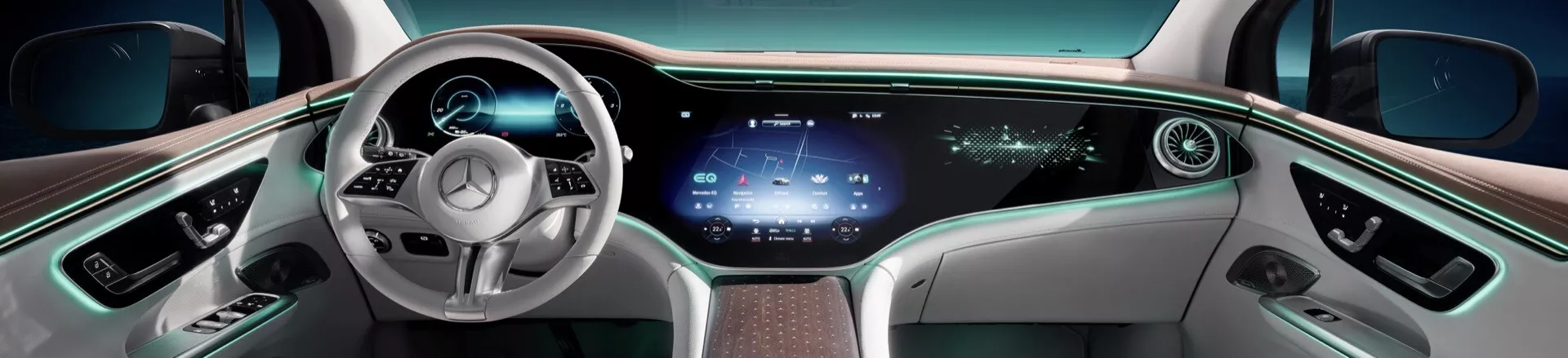 Vista interior panorámica del Mercedes-Benz EQE-SUV 2023 centrada en el tablero y el volante desde una perspectiva central trasera, destacando características tecnológicas avanzadas, iluminación ambiental lujosa y controles de cabina integrales.