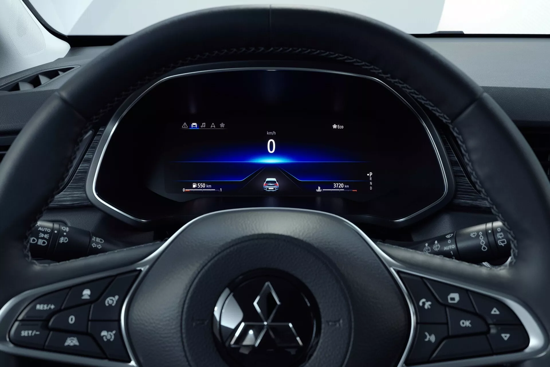 Vista interior del Mitsubishi ASX 2023 (2ª generación) desde el asiento del conductor, enfocando el volante multifunción de tres radios con botones para medios, teléfono, control de crucero y el emblema del fabricante. Detrás, un panel de instrumentos totalmente digital muestra un velocímetro a 0 km/h, señales de giro, hora y odómetro. El diseño tipo cabina indica un enfoque centrado en el conductor con una estética moderna y elegante que enfatiza la tecnología y el fácil acceso a la información y controles del vehículo.