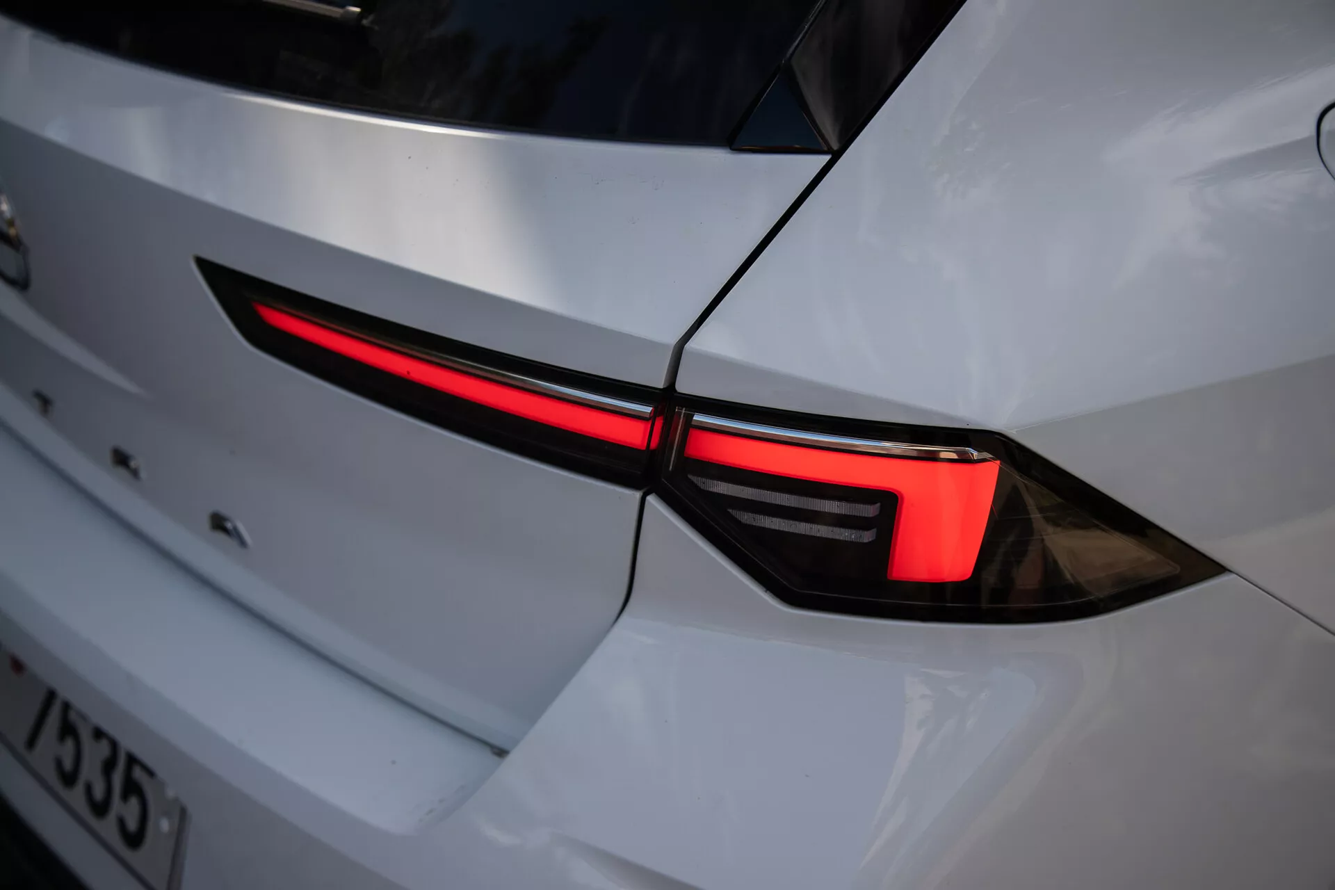Primer plano de la luz trasera izquierda del Opel Astra 2022, mostrando un diseño LED elegante y su integración en la carrocería blanca con una estética deportiva