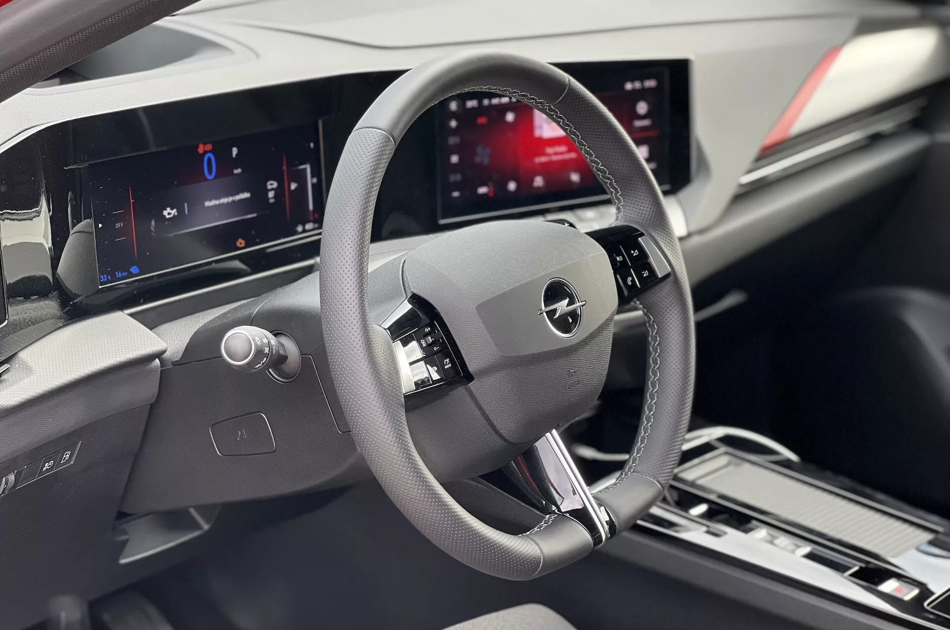 Vista interior de un Opel Astra 2022 enfocada en el área del conductor con volante detallado, cuadro de instrumentos digital y pantalla de infoentretenimiento central
