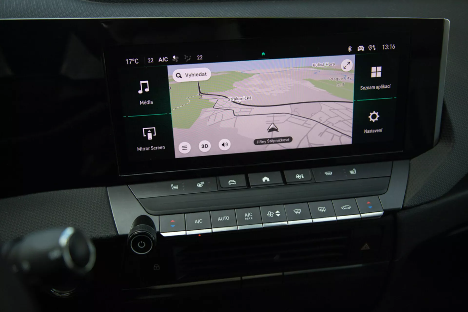 Vista detallada del sistema de infoentretenimiento y controles climáticos del Opel Astra 2022 en la consola central, mostrando la navegación GPS en la pantalla, conectividad Bluetooth y ajustes de temperatura