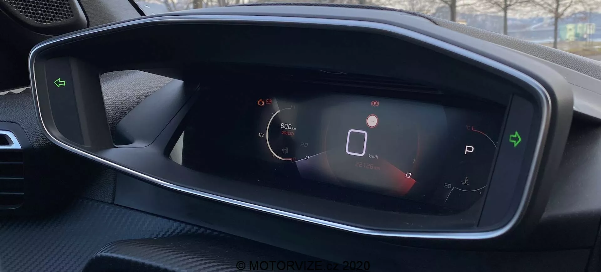 Vista de cerca del panel de instrumentos digital del Peugeot 2008 2020, con indicador de velocidad, icono de estado del vehículo, selección de marcha en modo de estacionamiento, símbolo de batería y otros indicadores de estado. Diseño limpio y de alto contraste desde la perspectiva del conductor.