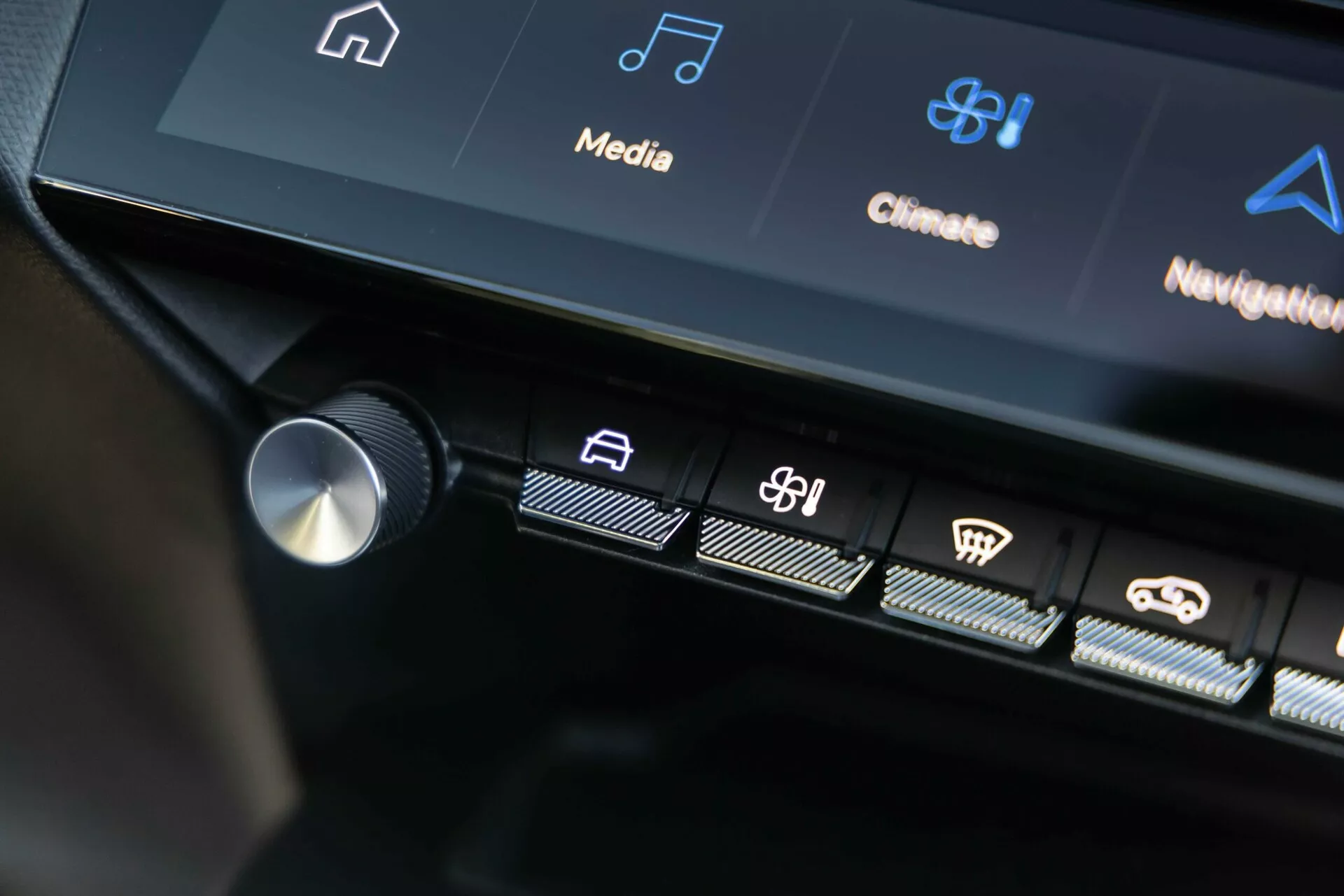 Interfaz de control central del Peugeot 408 2023 mostrando botones táctiles iluminados y parte de la pantalla táctil con iconos de infotenimiento y control climático, destacando la tecnología avanzada del vehículo