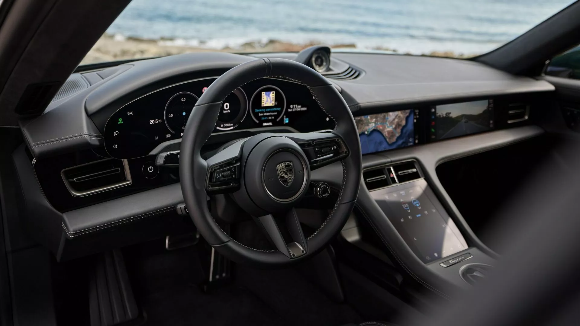 Vista interior del Porsche Taycan Y1A facelift 2024 desde el asiento trasero mostrando el volante, el tablero digital y la consola central con avanzadas características tecnológicas