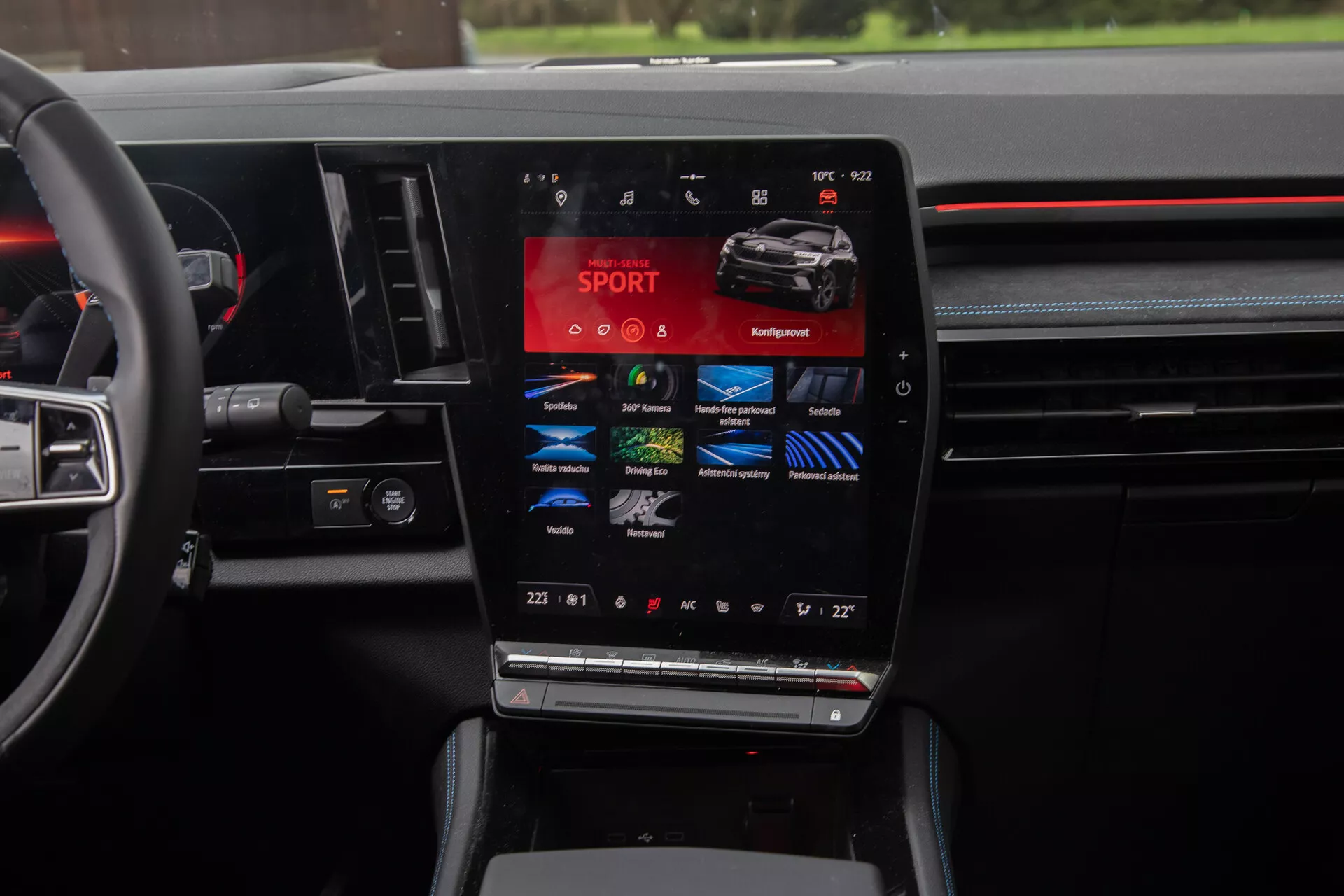 Vista interior del Renault Austral 2022 destacando la consola central con una gran pantalla táctil vertical que muestra modos de conducción como SPORT, Comfort, Eco, junto con configuraciones de control climático de doble zona, y controles de volante multifunción, encapsulando la esencia de la tecnología automotriz moderna y diseño de lujo.