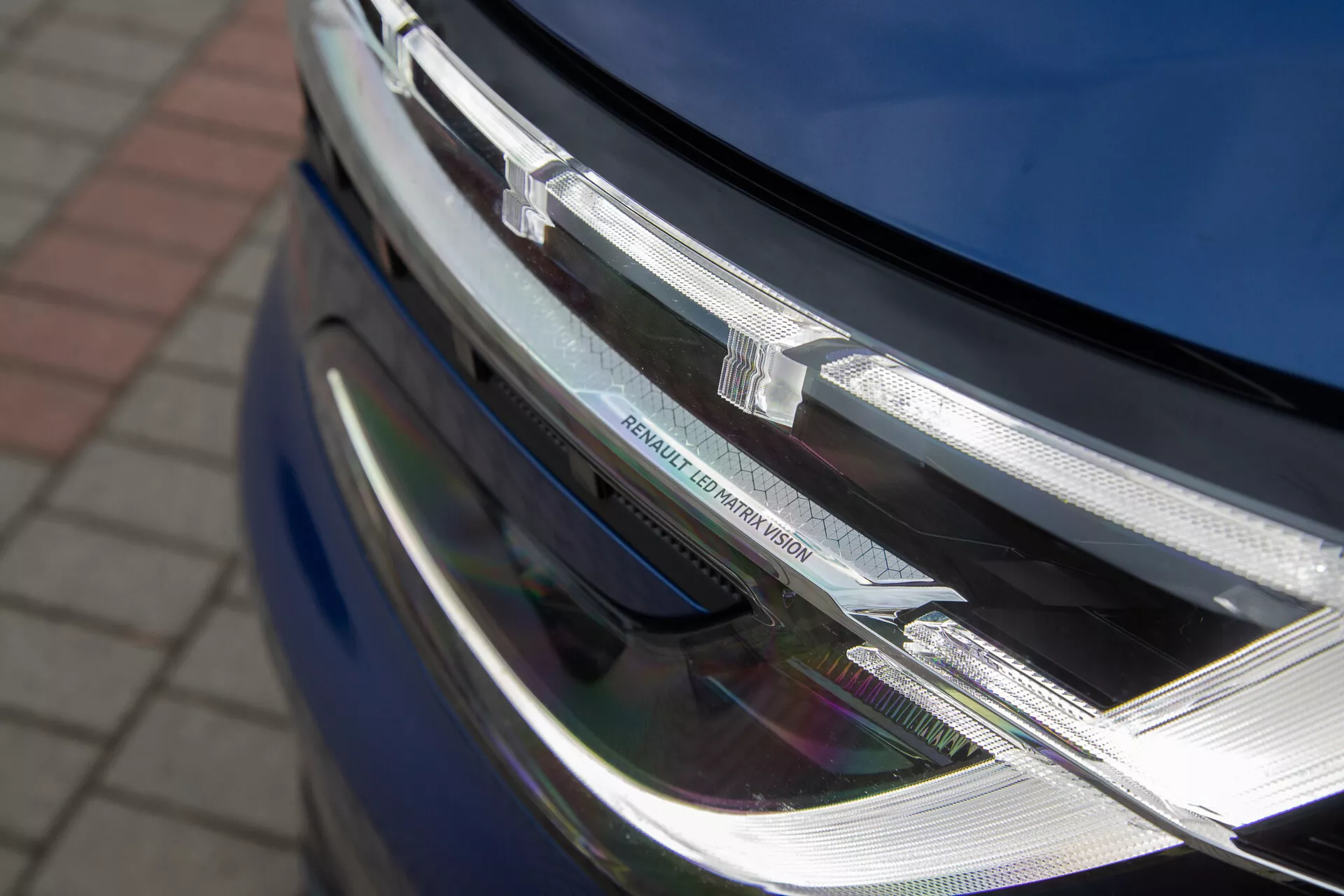 Vista detallada de la sección frontal del Renault Austral 2022 mostrando el faro LED y el ensamblaje de la parrilla cromada con el emblema del fabricante, enfatizando su diseño moderno y la tecnología de iluminación sofisticada.