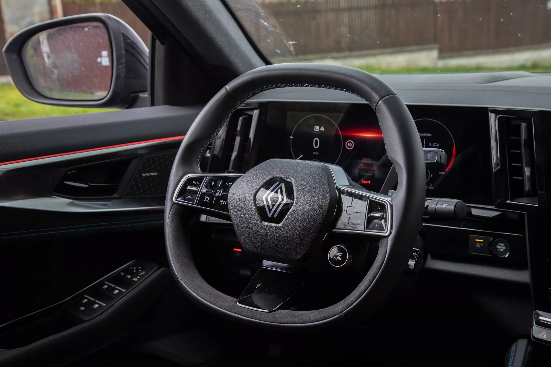 Foto del interior del Renault Austral 2022 desde la perspectiva del conductor que muestra el volante con controles montados, el cuadro de instrumentos digital y parte de la consola central.