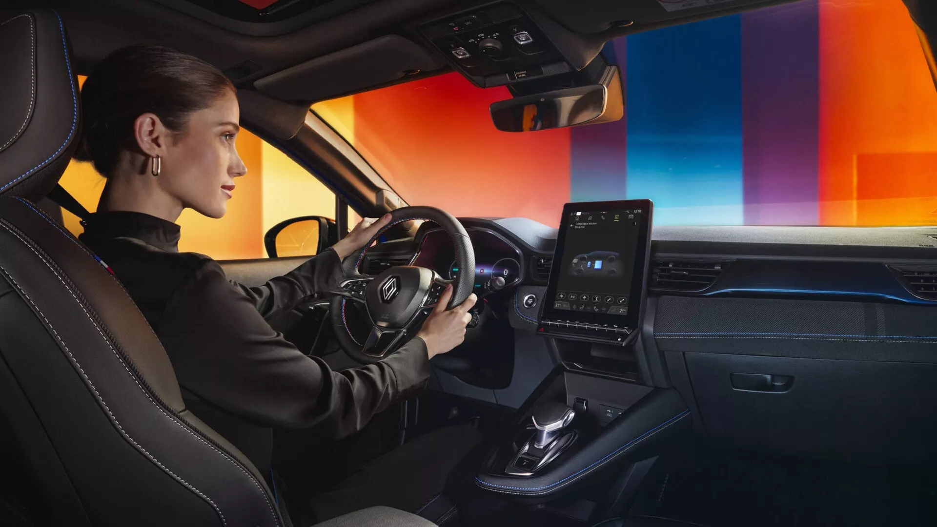 Interior del Renault Captur II Facelift 2024 mostrando la vista del lado del conductor con énfasis en los controles del volante, tablero elegante con sistema de infoentretenimiento táctil vertical y asientos de cuero premium