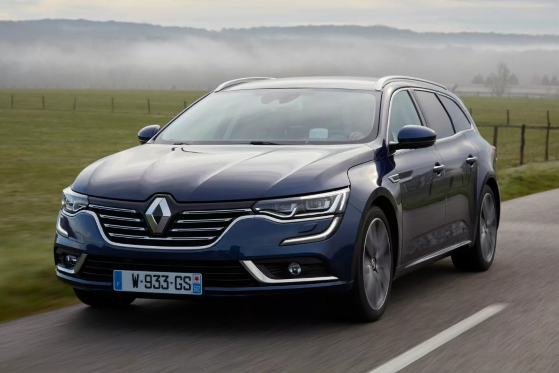 Renault Talisman Grandtour 2016 en movimiento, visto desde un ángulo frontal lateral que muestra luces LED y pintura metálica
