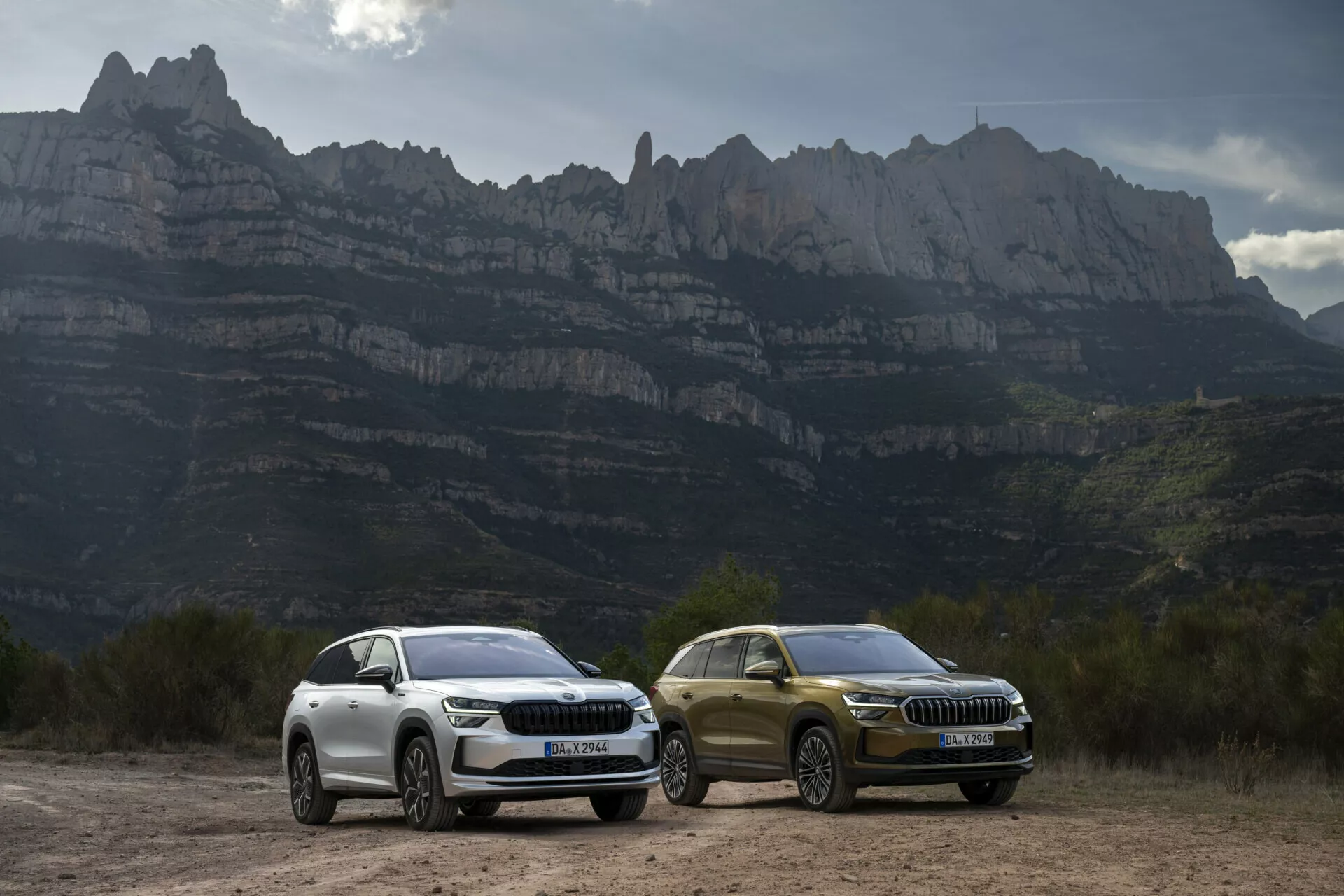SUVs Skoda Kodiaq 2024 con luces LED y detalles de diseño de lujo aparcados al aire libre contra un telón de fondo montañoso, destacando características aerodinámicas, llantas de aleación y tecnología avanzada adecuada para la conducción aventurera.