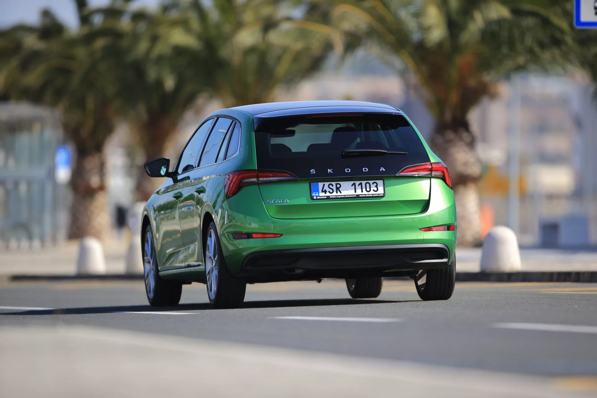 Škoda Scala de 2019 en movimiento, mostrado desde una vista trasera, destacando características de diseño moderno que incluyen luces traseras LED, spoiler trasero integrado y puntas de escape dobles, capturado con una perspectiva dinámica desde un ángulo bajo.