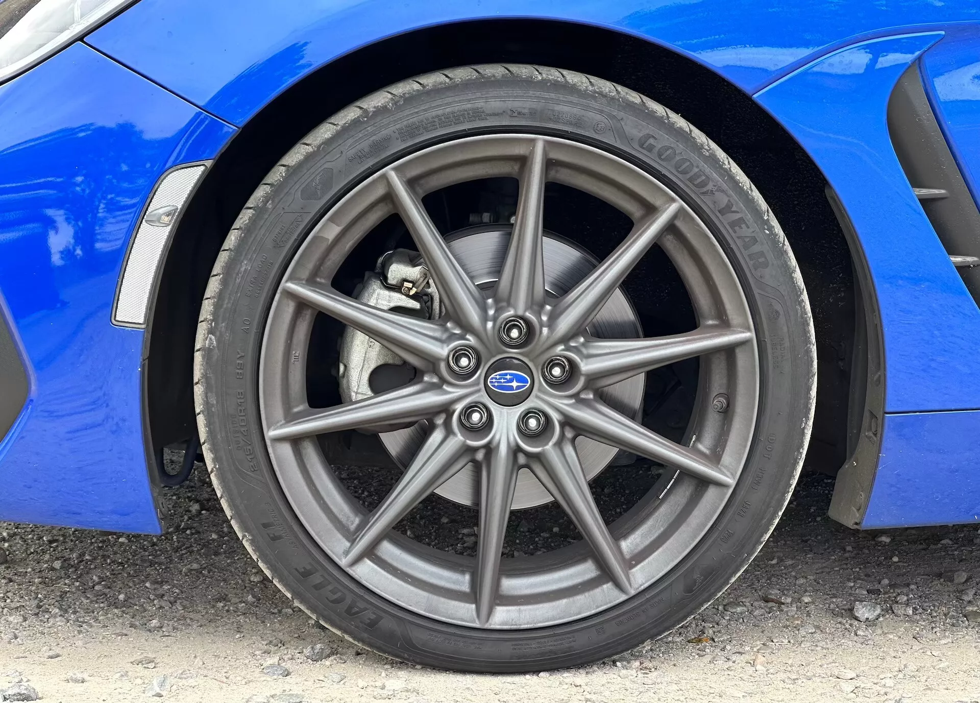 Imagen de primer plano del Subaru BRZ 2023 mostrando la rueda de aleación delantera y el neumático Continental, con carrocería azul vibrante visible
