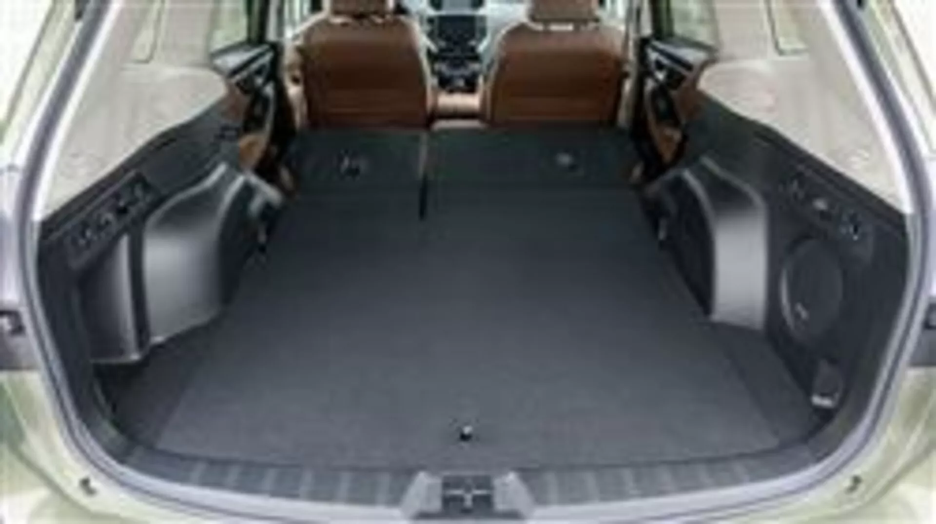 Espacio del maletero del Subaru Forester 2015 con los asientos traseros abatidos, mostrando el área de carga vacía y el diseño interior de lujo en cuero marrón, visto desde una perspectiva elevada