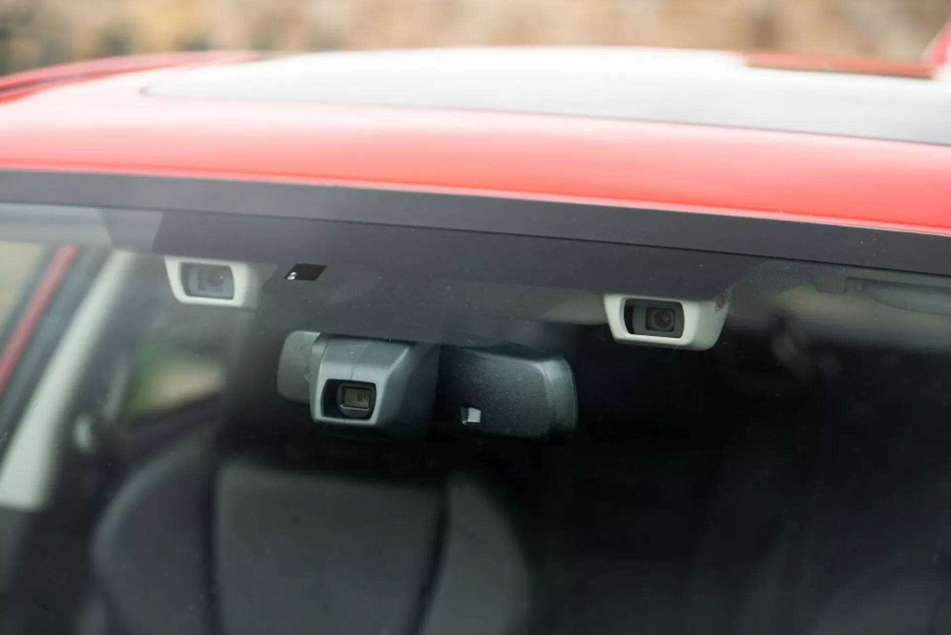 Primer plano de las cámaras ADAS montadas en la parte trasera del parabrisas de un Subaru Impreza 2018, resaltando la tecnología de seguridad avanzada