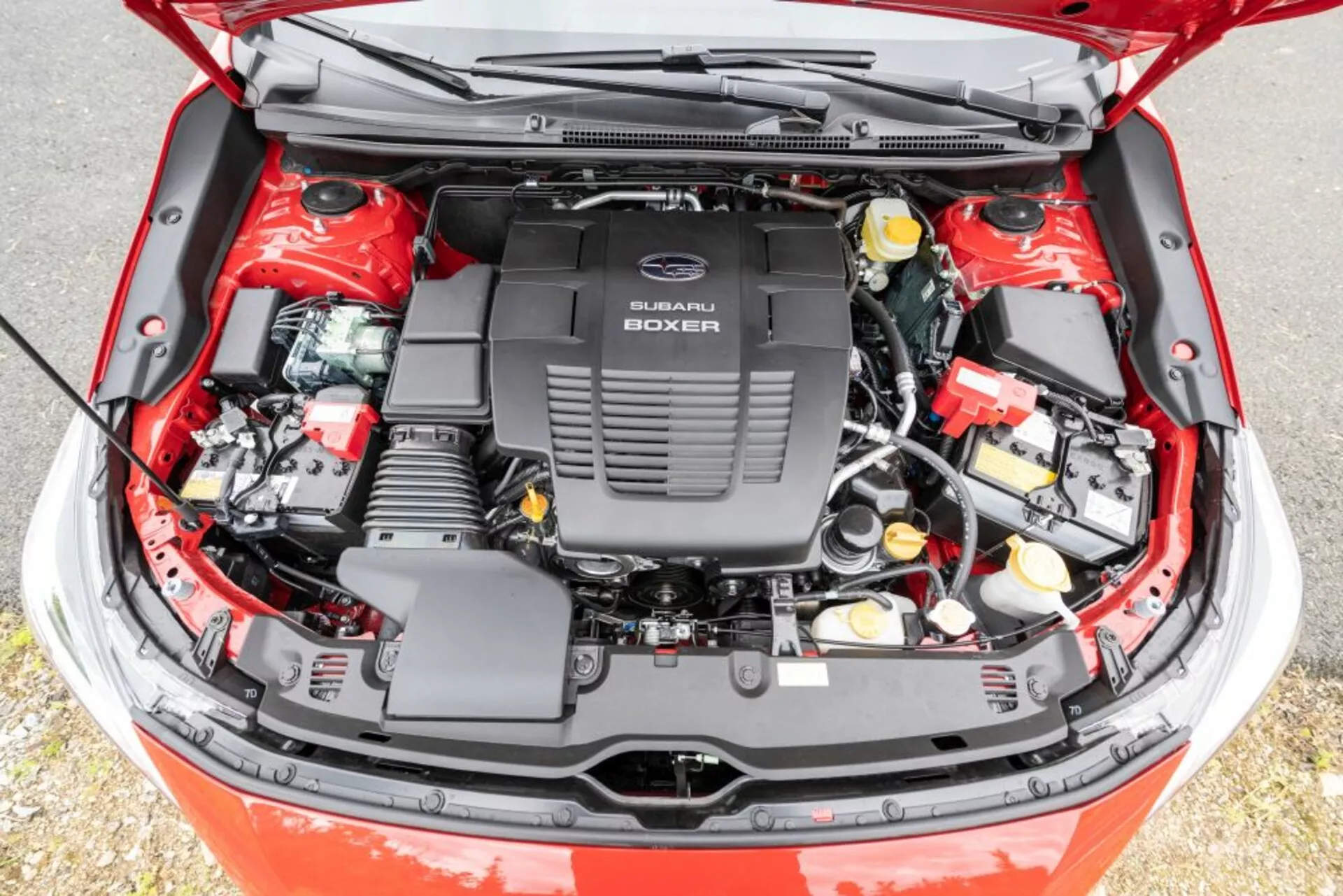 Vista detallada del compartimento del motor abierto de un Subaru Impreza 2018 con motor Subaru Boxer, mostrando componentes mecánicos y eléctricos desde un ángulo elevado