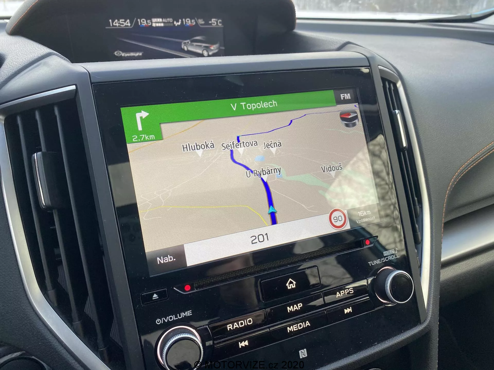 Consola central del Subaru XV 2018 enfocada en el sistema de infoentretenimiento que muestra un mapa de navegación en la pantalla, con botones para volumen, radio, medios, aplicaciones y configuraciones del coche, controles adicionales de clima parcialmente visibles, mostrando una ruta GPS, la hora (14:54), la temperatura ambiente (-5.5°C), indicadores de conectividad que sugieren funcionalidad Bluetooth o Wi-Fi, destacando la tecnología automotriz moderna.