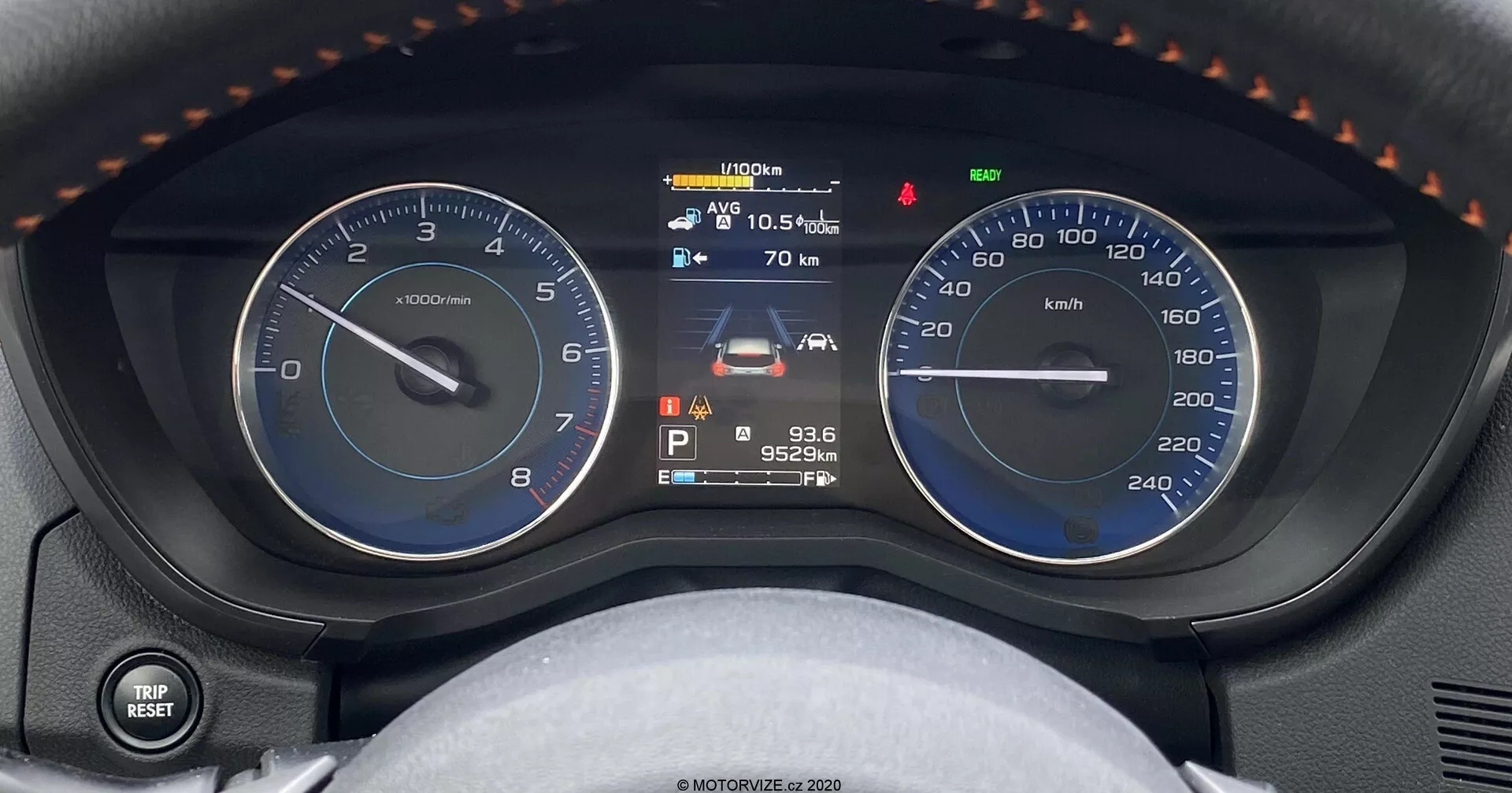 Vista de cerca del cuadro de instrumentos del Subaru XV 1.6i Trend Lineartronic, mostrando un tacómetro analógico, una pantalla multifuncional digital y un velocímetro analógico. La pantalla digital central muestra el indicador de combustible, el estado del vehículo, la temperatura exterior de 10.5°C, una advertencia de mantenimiento, la marcha en Parking, un odómetro con 95,249 km y la hora a las 9:36. La imagen captura el tablero desde el asiento del conductor, con detalles adicionales como un mando para luces e intermitentes a la izquierda y una vista parcial del volante con descansos para pulgares y costuras.