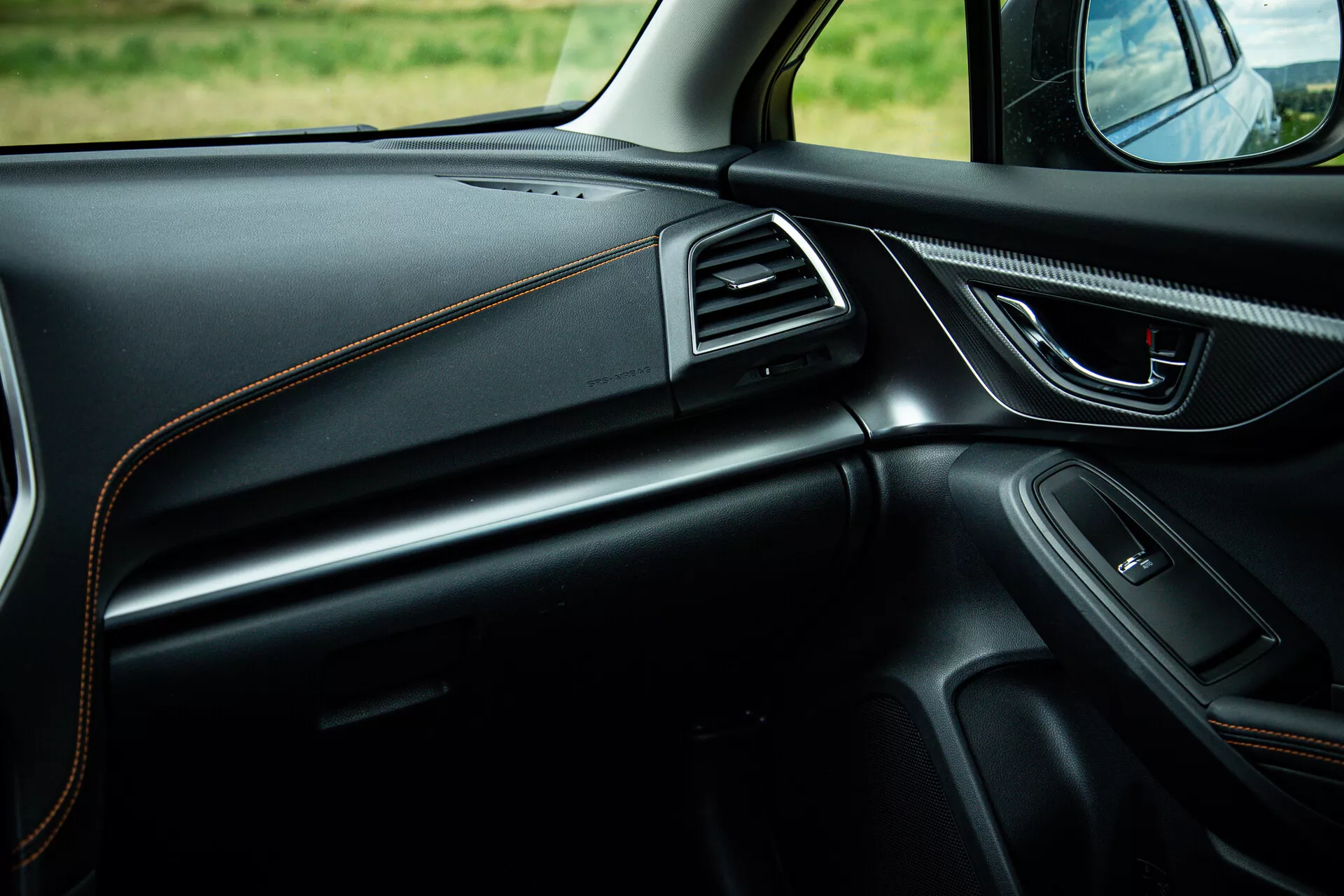 Vista interior del Subaru XV 2021 concentrándose en el lado del pasajero mostrando diseño elegante del tablero con costura contrastante, manija de la puerta ergonómica con controles de potencia, altavoz integrado, ventilaciones de aire acentuadas en cromo y iluminación ambiental