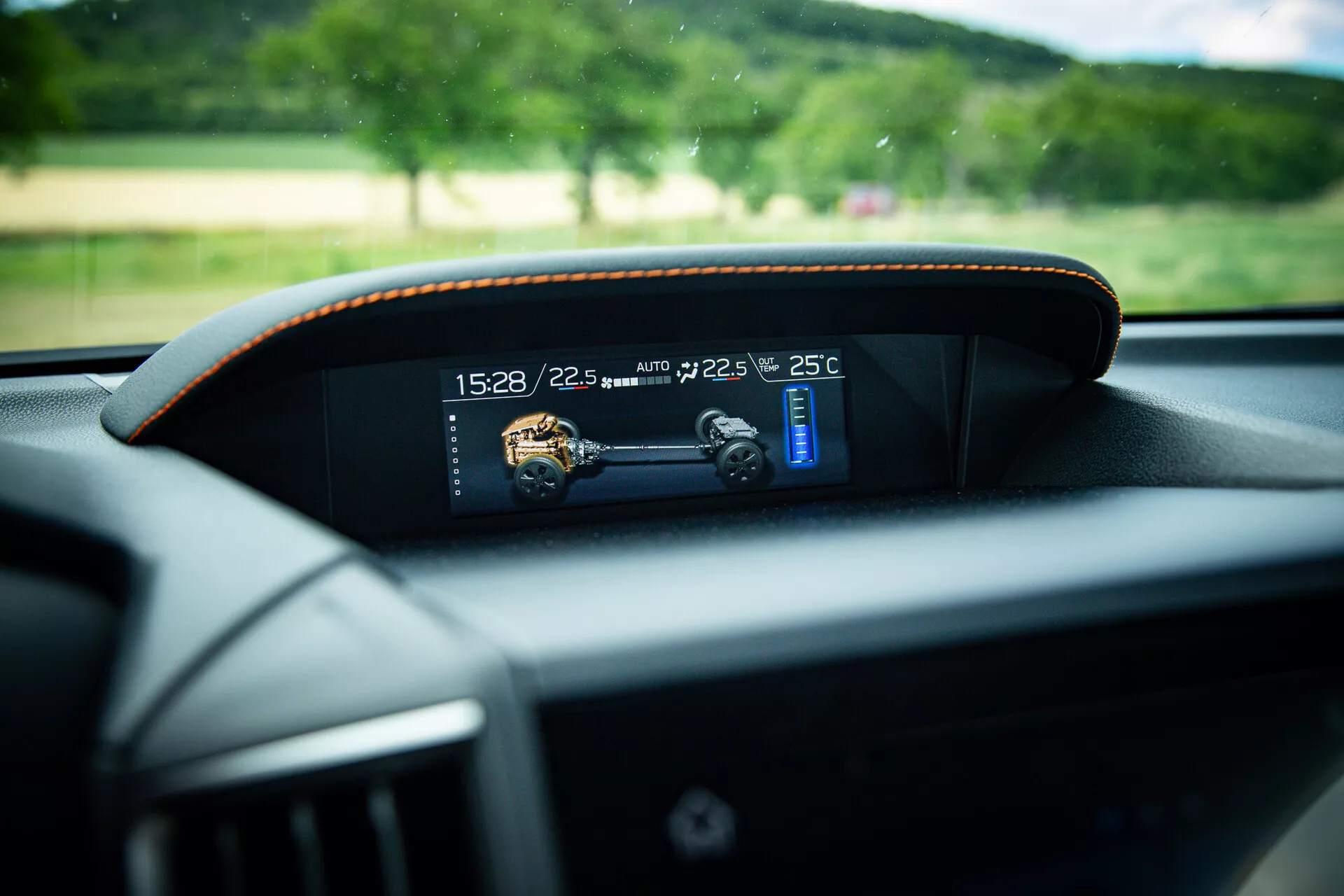 Vista cercana del tablero digital moderno en un Subaru XV 2021, mostrando indicadores de tiempo, temperatura y velocidad con costuras de contraste sutil alrededor del marco, tomada desde la perspectiva del asiento del conductor