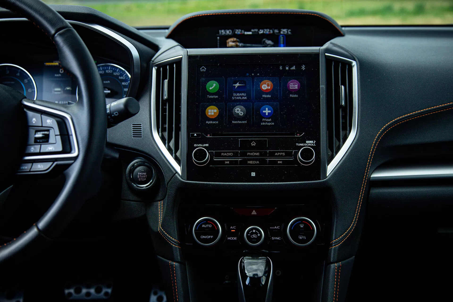 Interior del Subaru XV 2021 destacando la consola central y el sistema de infoentretenimiento desde una perspectiva del asiento trasero, mostrando la pantalla táctil con íconos de aplicaciones, botones de control de audio y clima, reflejando tecnología avanzada y diseño de lujo