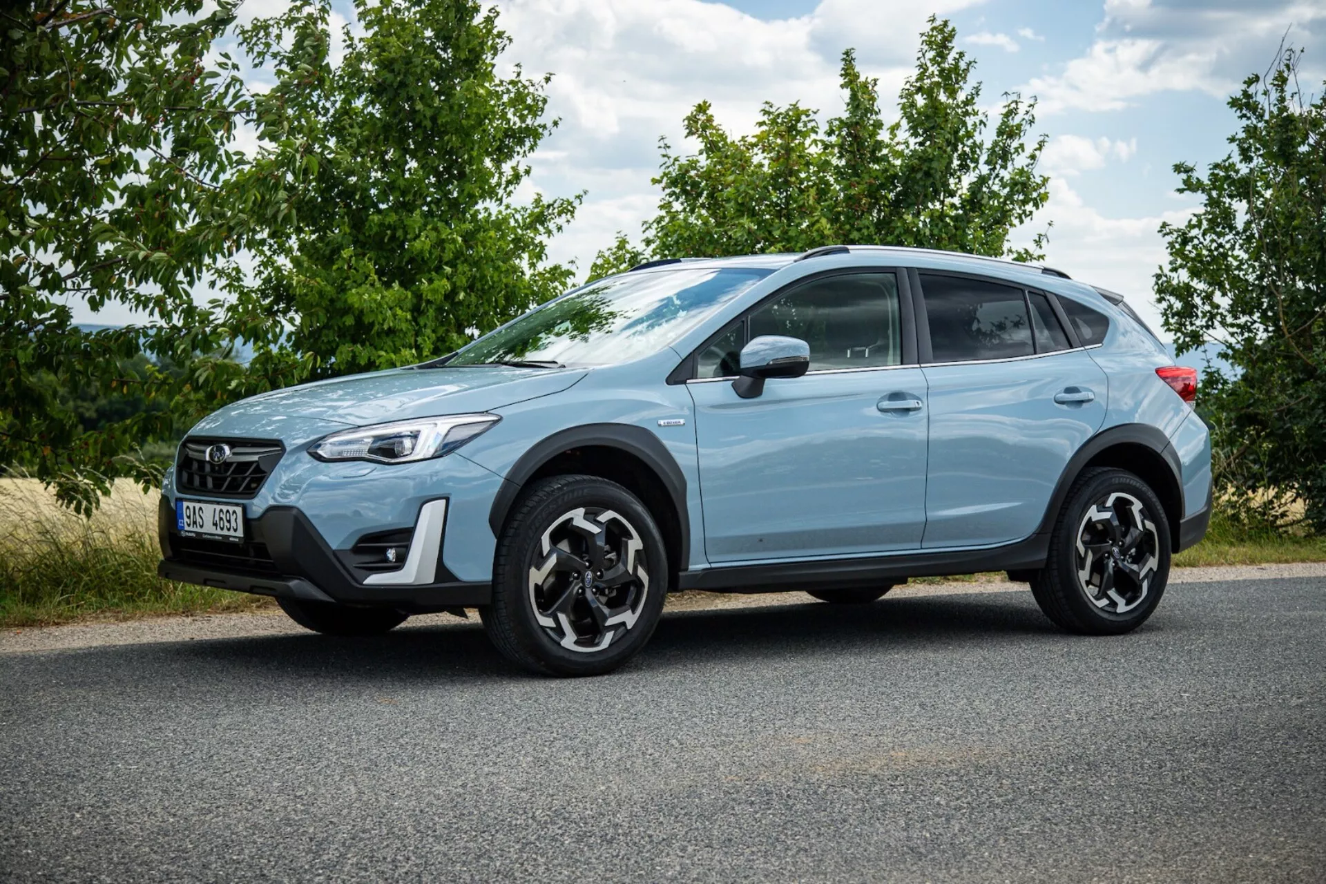 SUV crossover Subaru XV 2021 azul claro estacionado en asfalto mostrando perfil lateral, llantas de aleación negras distintivas, luces traseras LED, alta distancia al suelo para uso urbano y ligero fuera de carretera, y características de seguridad modernas