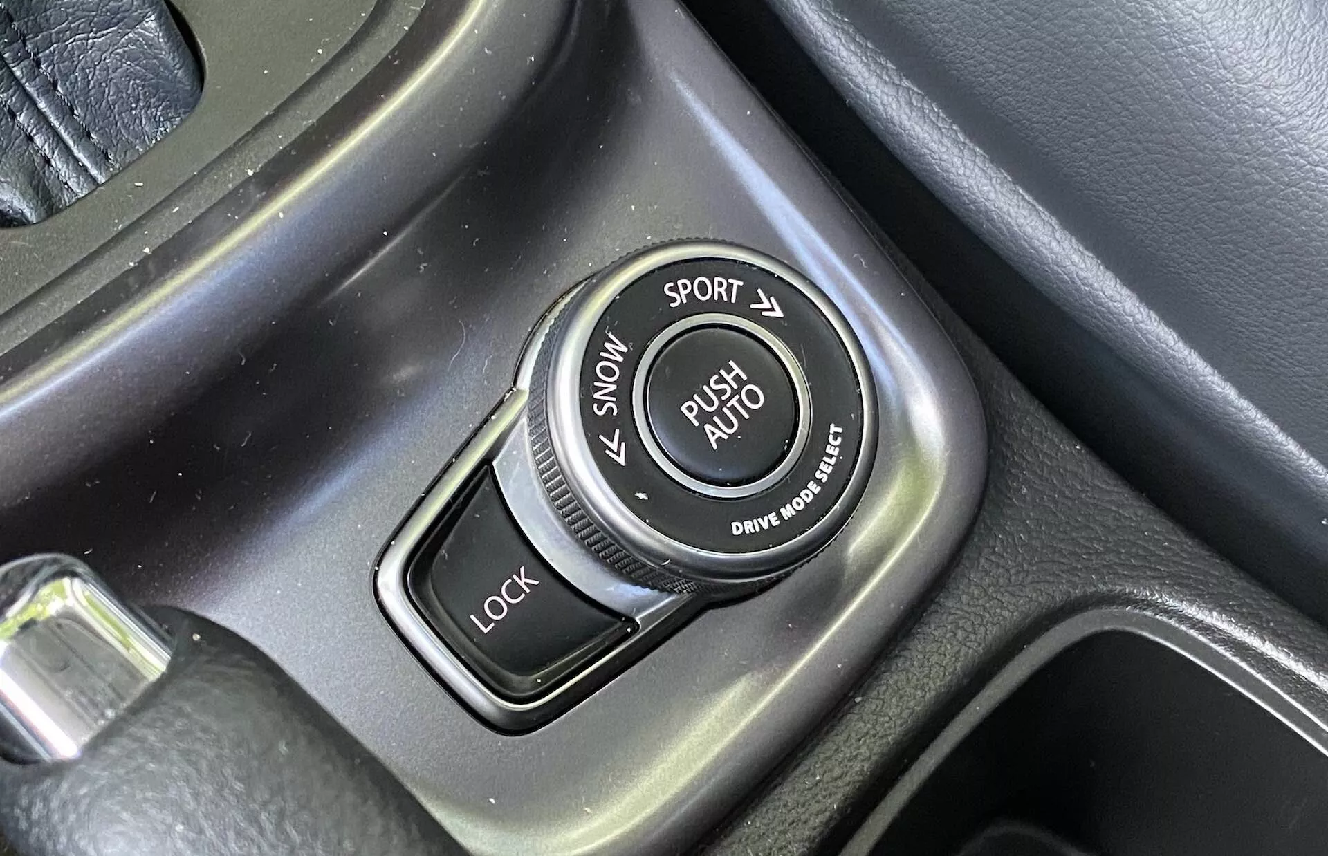 Primer plano del selector de modos de conducción en la consola central de un Suzuki Vitara 2018 con etiquetas para los modos SNOW, SPORT, LOCK y AUTO, superficie texturizada y detalles metálicos cepillados.