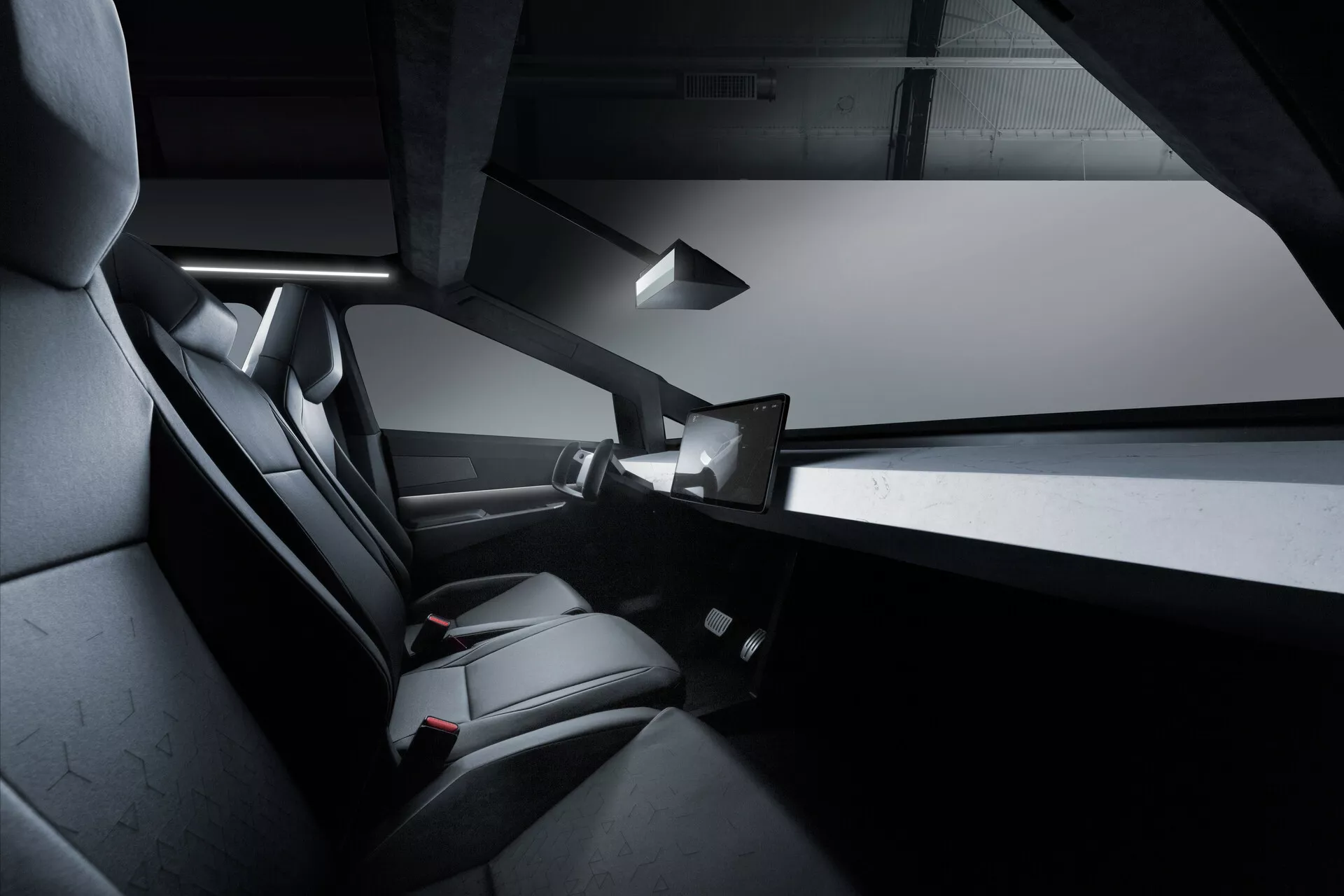 Vista interior del Tesla Cybertruck 2021, centrada en el compartimento trasero de pasajeros. La imagen resalta los asientos negros y elegantes, probablemente de cuero, con énfasis en la comodidad y el diseño, ventanas de puerta sin marco parcialmente visibles, una consola central delgada, una luz interior superior y una interfaz táctil montada en la parte trasera. El diseño es minimalista con líneas angulares y un esquema monocromático.