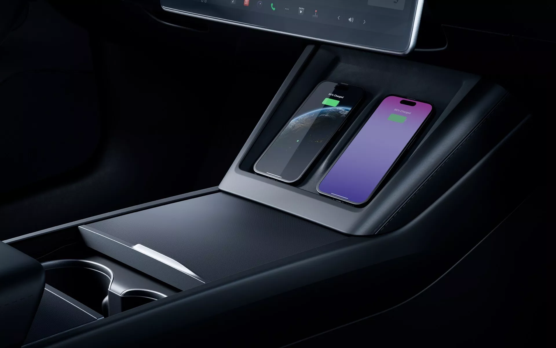 Vista cercana de la consola central del Tesla Model 3 2023 facelift mostrando la almohadilla de carga inalámbrica, compartimientos de almacenamiento, posavasos, materiales premium, iluminación ambiental y una pantalla digital