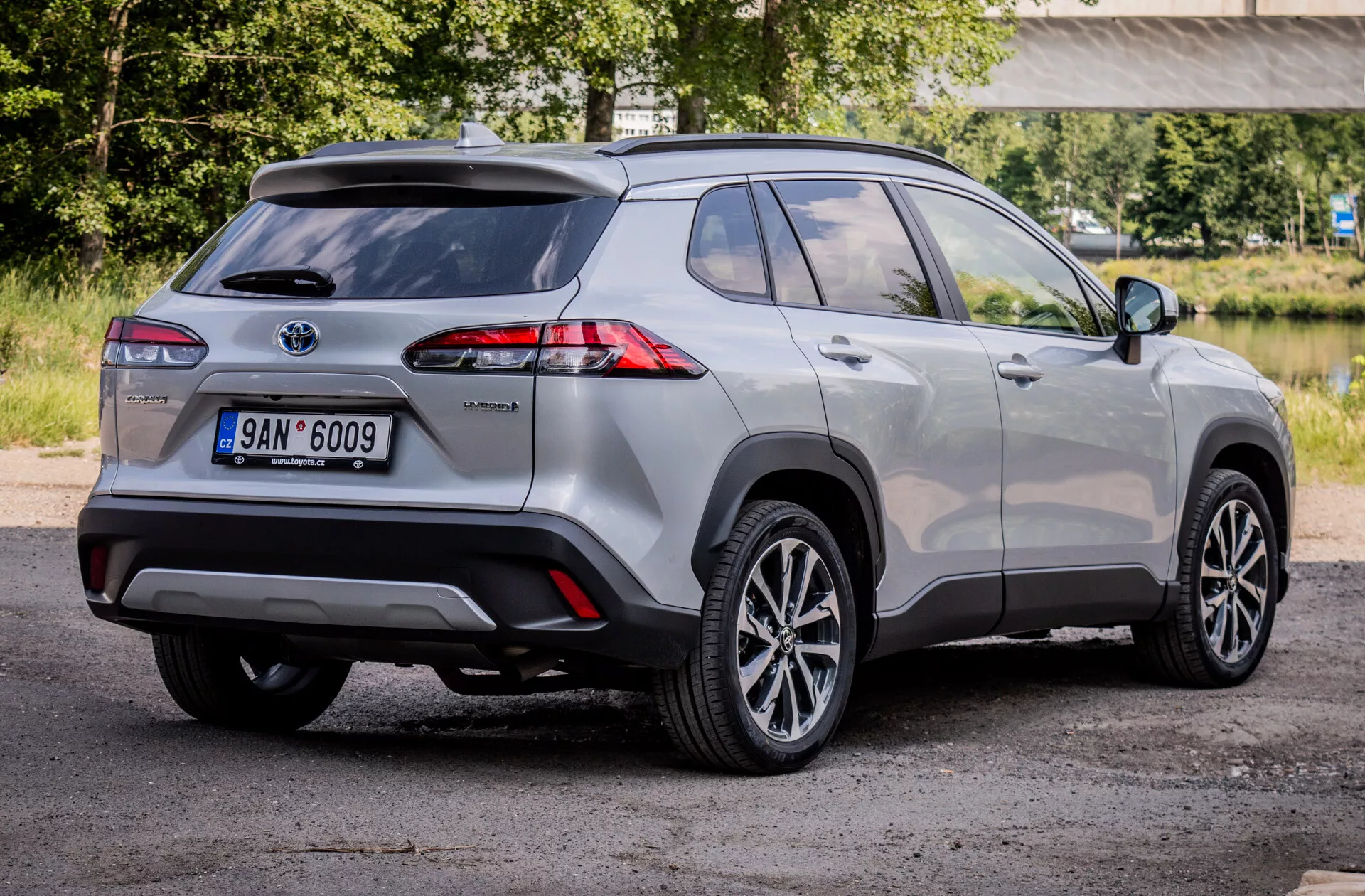 SUV compacto híbrido Toyota Corolla Cross 2022 mostrando luces traseras LED avanzadas, ruedas de aleación y características de seguridad desde una vista trasera de tres cuartos.