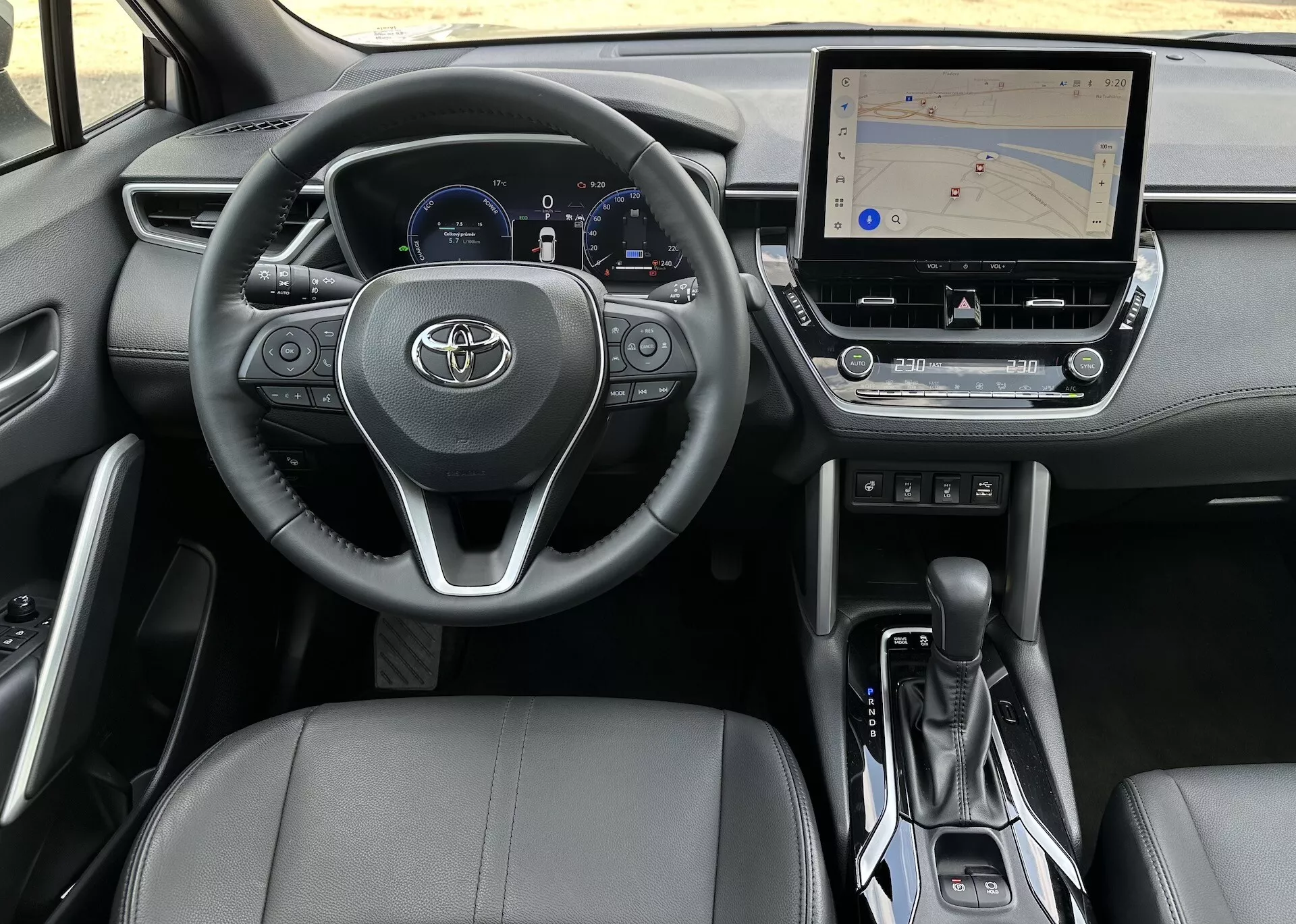 Interior del Toyota Corolla Cross 2022 desde la perspectiva del conductor mostrando el volante, el cuadro de instrumentos, la consola central y el asiento del pasajero