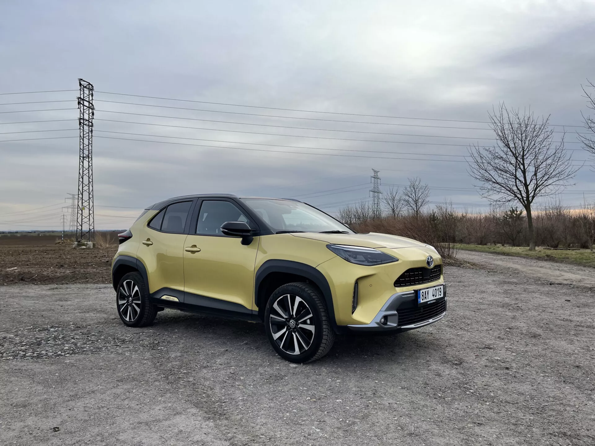 SUV compacto Toyota Yaris-Cross 2021 estacionado en grava, mostrando su carrocería de dos tonos, faros LED, ruedas de aleación y características modernas