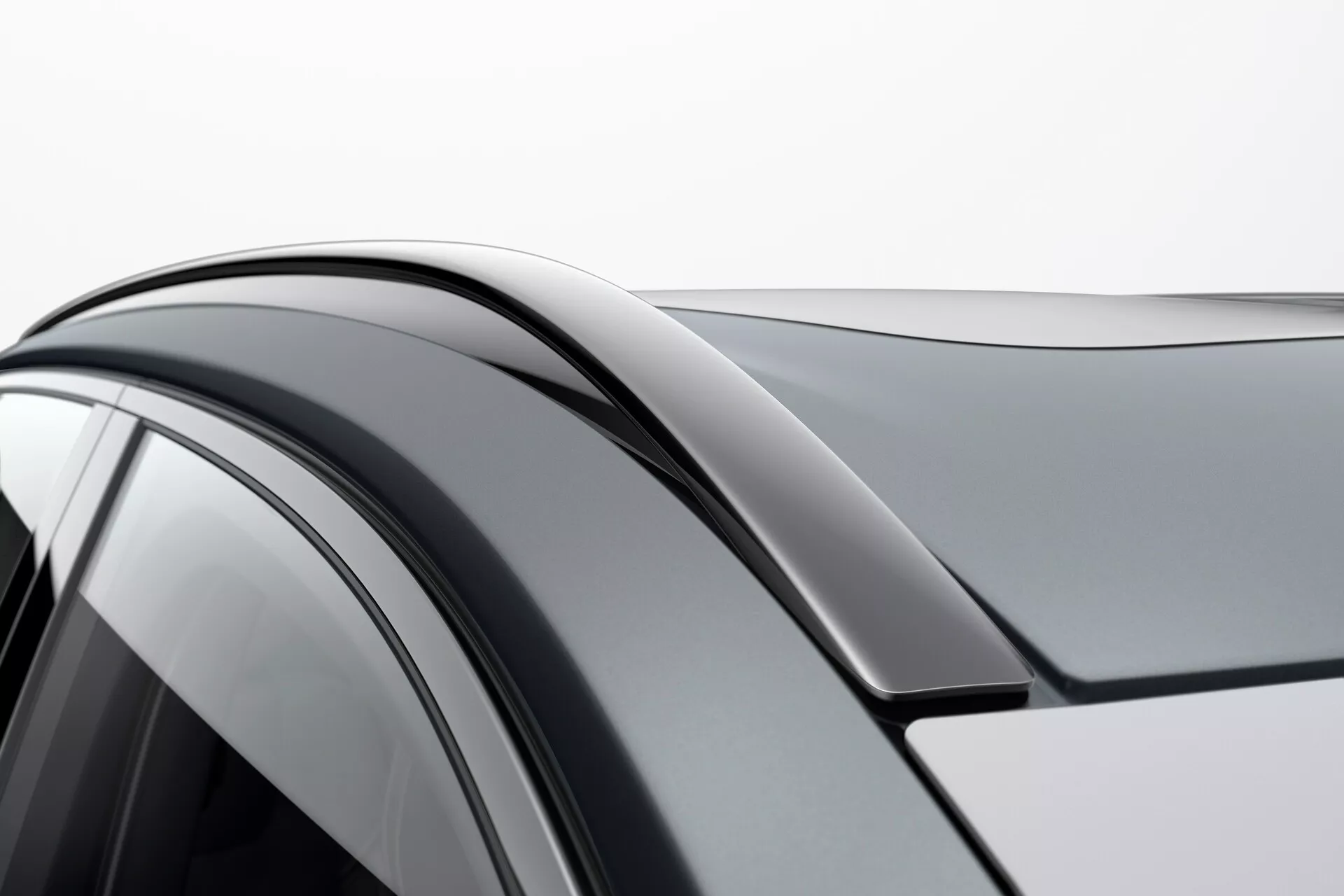 Detalle en primer plano de un Volvo XC90 2015 de segunda generación enfocado en el lado derecho, mostrando la línea del techo, el marco superior de la puerta y la ventana lateral con vidrio tintado; destacando la transición suave y el diseño aerodinámico.