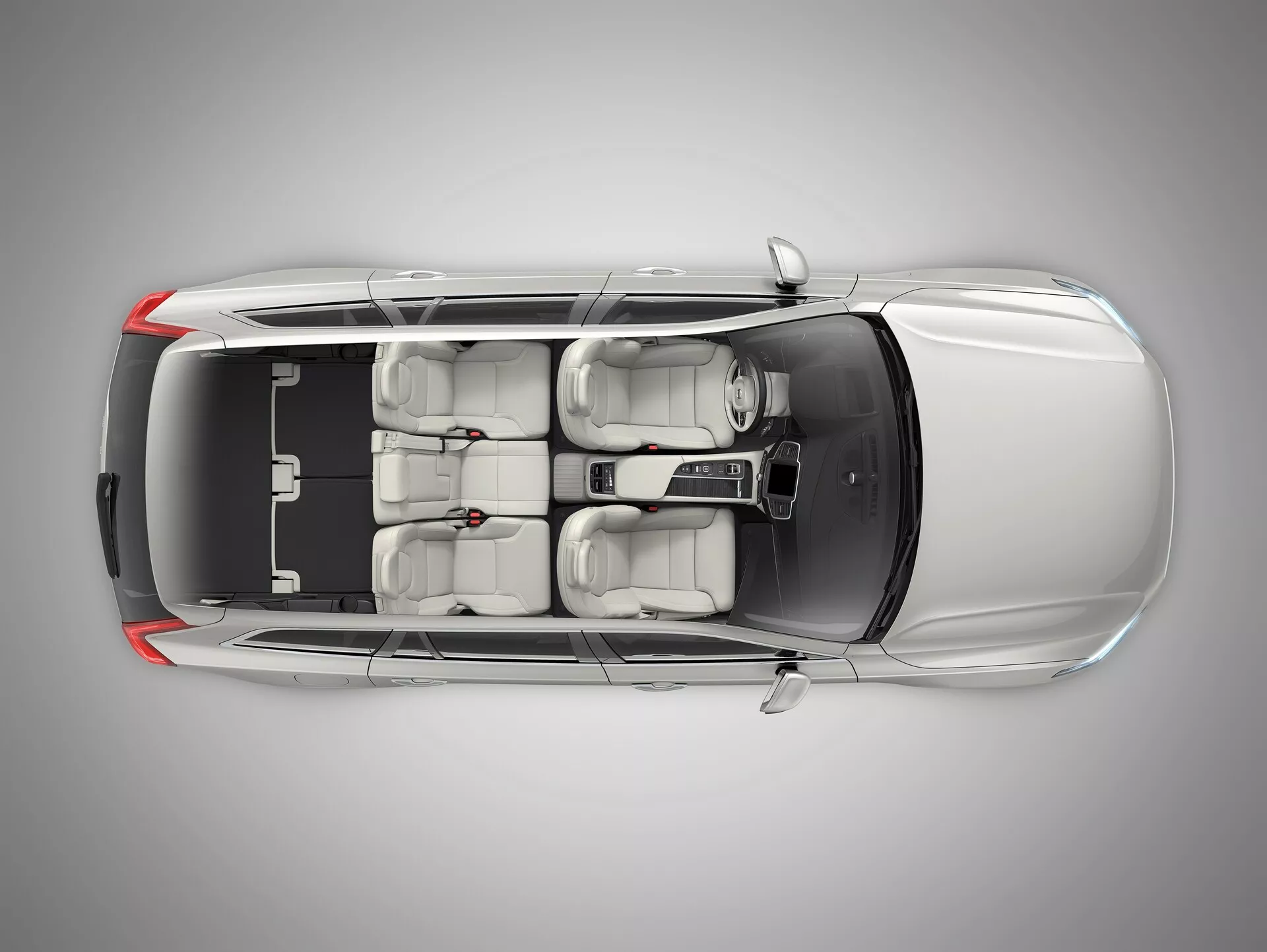 Vista de pájaro desde arriba del Volvo XC90 2015 metálico que muestra el techo negro en contraste, diseño aerodinámico, techo solar, dos filas de asientos con asientos delanteros ajustables avanzados, consola central de control y ventanas tintadas, centrado en un estudio profesional.