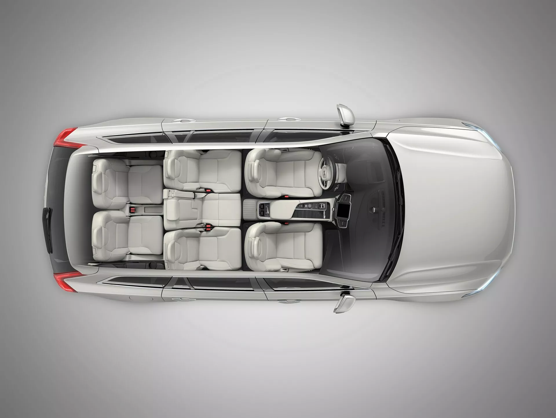 Vista superior del Volvo XC90 2015 (2ª generación), mostrando el techo con un panel de techo solar o moonroof, cuatro puertas con manillas al ras y una disposición de asientos de tres filas para siete pasajeros, lo que indica un diseño moderno y configuración de conducción a la izquierda.
