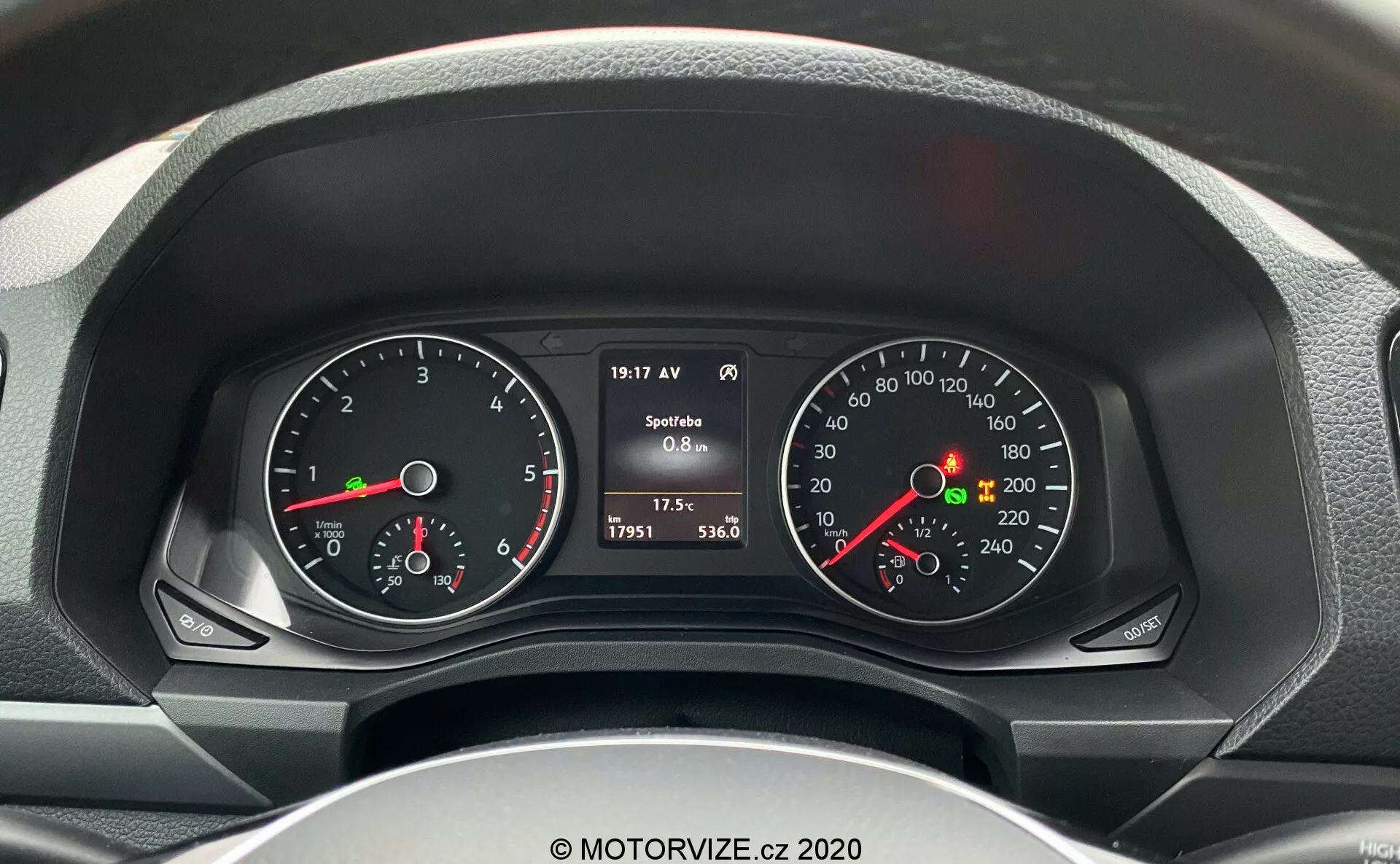 Vista detallada del cuadro de instrumentos del conductor en un VW-Nutzfahrzeuge Amarok 2016 desde el asiento del conductor, mostrando tacómetro y velocímetro con pantallas digitales y analógicas, incluyendo RPM del motor, velocidad, nivel de combustible, temperatura del motor y datos del vehículo como velocidad actual, lectura del odómetro, temperatura exterior y consumo de combustible.