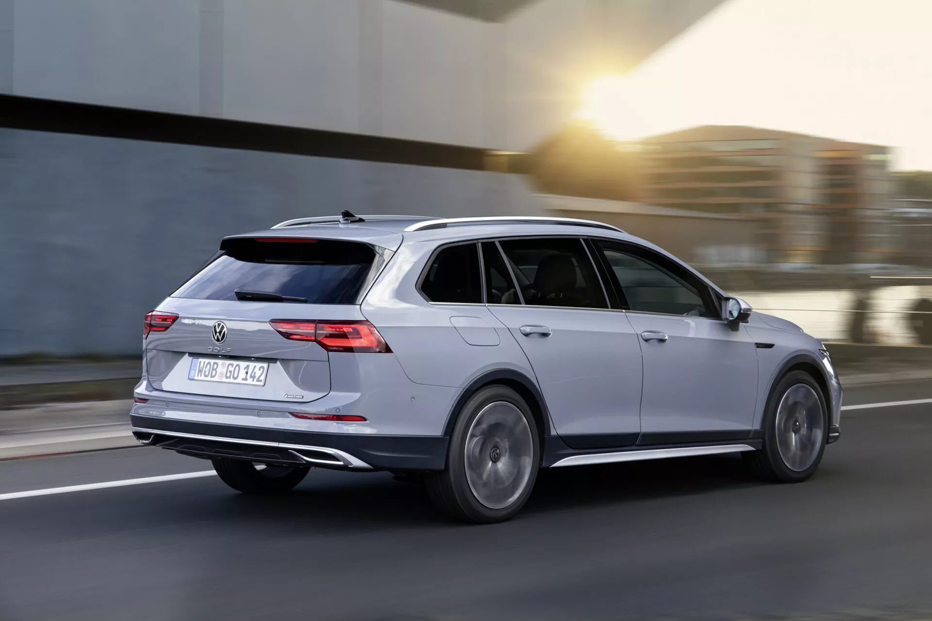 Vagón de estación Volkswagen Golf Alltrack 2017 en movimiento, capturado en una vista dinámica tres cuartos trasera mostrando cuerpo plateado, luces traseras LED, ruedas de aleación y diseño aerodinámico sobre un fondo de carretera desenfocado.